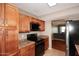 Well-lit kitchen with wooden cabinets, black appliances, and tile flooring at 5122 E Shea Blvd # 1117, Scottsdale, AZ 85254