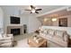 Bright living room featuring a fireplace, ceiling fan, and access to dining area with a modern chandelier at 5122 E Shea Blvd # 1117, Scottsdale, AZ 85254