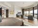 An open and airy main bedroom boasts a sitting area, access to the backyard, hardwood floors, and neutral decor at 5630 E Rockridge Rd, Phoenix, AZ 85018