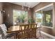 Charming dining room with a wooden table, chandelier, and backyard views at 9814 W Rowel Rd, Peoria, AZ 85383