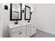 Bathroom with dual sinks, black framed mirrors, and elegant patterned tile floor at 16590 N Dante Way, Maricopa, AZ 85138