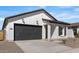 Charming single-story home featuring a gray garage door and complementary desert landscaping at 16590 N Dante Way, Maricopa, AZ 85138