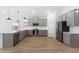 Spacious kitchen featuring gray cabinets, stainless appliances, and wood-look tile flooring at 16590 N Dante Way, Maricopa, AZ 85138