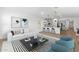 Open-concept living room with white sofa, modern art, and eat-in kitchen at 16590 N Dante Way, Maricopa, AZ 85138