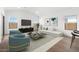 Cozy living room featuring a plush sofa, entertainment center, and large windows at 16590 N Dante Way, Maricopa, AZ 85138