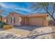 Tan house with a two-car garage and brick driveway at 4219 N 161St Ave, Goodyear, AZ 85395