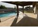 Covered patio with exposed beams overlooks a pristine private pool and lush backyard, ideal for outdoor living at 4643 W Laurel Ln, Glendale, AZ 85304