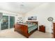 Main bedroom with a sleigh bed, sliding door to patio, and wood furniture at 9405 E Cherrywood Dr, Sun Lakes, AZ 85248
