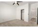 Neutral bedroom with a carpeted floor, ceiling fan, closet, and a white door at 135 E Julian Dr, Gilbert, AZ 85295