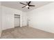 Bright carpeted bedroom featuring a ceiling fan and sliding closet doors at 135 E Julian Dr, Gilbert, AZ 85295