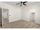 Spacious carpeted bedroom featuring a ceiling fan and doorways to a walk-in closet and hallway at 135 E Julian Dr, Gilbert, AZ 85295