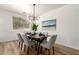 Bright dining room featuring a modern chandelier, wood floors, and seating for six at 135 E Julian Dr, Gilbert, AZ 85295