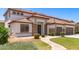 Welcoming home featuring stone accents, a tiled roof, and a well-maintained front yard with mature plants at 135 E Julian Dr, Gilbert, AZ 85295