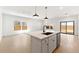 Bright, open kitchen with a quartz island, stainless steel appliances, and sliding glass doors to the backyard at 16580 N Dante Way, Maricopa, AZ 85138