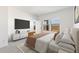 Bright staged main bedroom, showcasing a large bed, tv, and light-filled ambiance, perfect for relaxing and unwinding at 16580 N Dante Way, Maricopa, AZ 85138