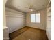 This bedroom has a ceiling fan, window with blinds, and shelving, creating an organized space at 18068 W Browning Dr, Surprise, AZ 85374
