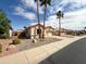 Inviting single-story home with palm trees in the front yard, adding a touch of desert charm at 18068 W Browning Dr, Surprise, AZ 85374