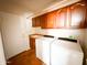 This laundry room has built in cabinets with a utility sink and modern, white washer and dryer at 18068 W Browning Dr, Surprise, AZ 85374