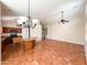 Open living room with tile floors, ceiling fan, neutral wall paint, and a glimpse of the kitchen at 18068 W Browning Dr, Surprise, AZ 85374
