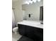 Modern bathroom with dark vanity, large mirror, and shower at 2738 E Cherry Hill E Dr, Gilbert, AZ 85298