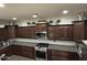 Gourmet kitchen with stainless steel appliances, granite countertops, and dark wood cabinets at 2738 E Cherry Hill E Dr, Gilbert, AZ 85298