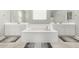 Elegant bathroom with double sinks, soaking tub, and tile flooring at 14271 W Alameda Rd, Surprise, AZ 85387