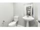 Simple pedestal sink and toilet in an updated powder room at 14271 W Alameda Rd, Surprise, AZ 85387