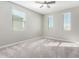 Spacious bedroom with three windows, ceiling fan, and neutral carpeting at 14271 W Alameda Rd, Surprise, AZ 85387
