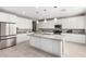 Kitchen boasts white cabinets, granite island, and stainless steel appliances at 14271 W Alameda Rd, Surprise, AZ 85387