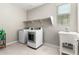 Laundry room with washer, dryer, shelving, and a utility sink at 14271 W Alameda Rd, Surprise, AZ 85387