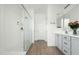 Spa-like bathroom with walk-in shower, double vanity, and gray cabinets at 17849 W Thistle Landing Dr, Goodyear, AZ 85338