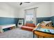bedroom with twin bed, couch, and built-in shelving at 17849 W Thistle Landing Dr, Goodyear, AZ 85338