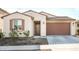Single-story home with two-car garage, neutral color palette, and landscaping at 17849 W Thistle Landing Dr, Goodyear, AZ 85338