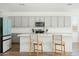 Modern kitchen with island, stainless steel appliances, and light gray cabinets at 17849 W Thistle Landing Dr, Goodyear, AZ 85338