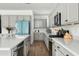 Modern kitchen with gray cabinets, quartz countertops, and stainless steel appliances at 17849 W Thistle Landing Dr, Goodyear, AZ 85338