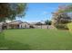 Large grassy backyard with block wall and partial view of house at 2042 E Aire Libre Ave, Phoenix, AZ 85022