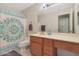 Clean bathroom with wood vanity and teal shower curtain at 2042 E Aire Libre Ave, Phoenix, AZ 85022