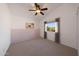 Bright bedroom showcasing a ceiling fan and a picture window with views of the surrounding neighborhood at 4121 E Milton Dr, Cave Creek, AZ 85331