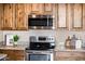 Kitchen with wood cabinets, granite counters, and stainless steel appliances at 13502 W Hyacinth Dr, Sun City West, AZ 85375