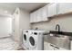 Laundry room with farmhouse-style cabinets, a large utility sink, and washer/dryer at 30017 N 60Th St, Cave Creek, AZ 85331