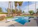 Stunning pool with diving board and pergola-covered outdoor kitchen surrounded by palms at 5074 E Cholla St, Scottsdale, AZ 85254