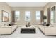 Spacious living room with two beige sofas, a coffee table, and large windows at 1 N Brenner Pass Rd, Queen Creek, AZ 85144