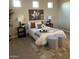 Cozy bedroom with neutral tones, featuring a comfortable bed, stylish ottomans, and decorative accents at 1923 E Zion Way, Chandler, AZ 85249