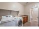 Laundry room with washer, dryer, cabinets, and shelving at 1923 E Zion Way, Chandler, AZ 85249