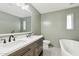 Neutral colored bathroom featuring a double sink vanity, soaking tub, and tile floors at 2265 E Elmwood St, Mesa, AZ 85213