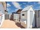Backyard with multiple structures, including a chicken coop, a gray shed, and a block wall fence at 2265 E Elmwood St, Mesa, AZ 85213