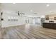 Bright living room boasts wood floors, neutral paint, a ceiling fan, modern kitchen, and access to the backyard at 2265 E Elmwood St, Mesa, AZ 85213