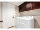Laundry room with washer, dryer, and dark wood cabinets at 30417 N 42Nd Pl, Cave Creek, AZ 85331