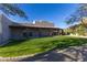 Spacious backyard with a grassy lawn, covered patio, and mature trees at 35931 N 82Nd Pl, Scottsdale, AZ 85266