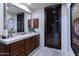 Bathroom with wooden vanity, stone flooring, and large mirror at 35931 N 82Nd Pl, Scottsdale, AZ 85266